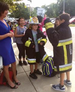 Dylan LaMonica and classmates dressed tried on a firefighter uniform outside the Murphy School.